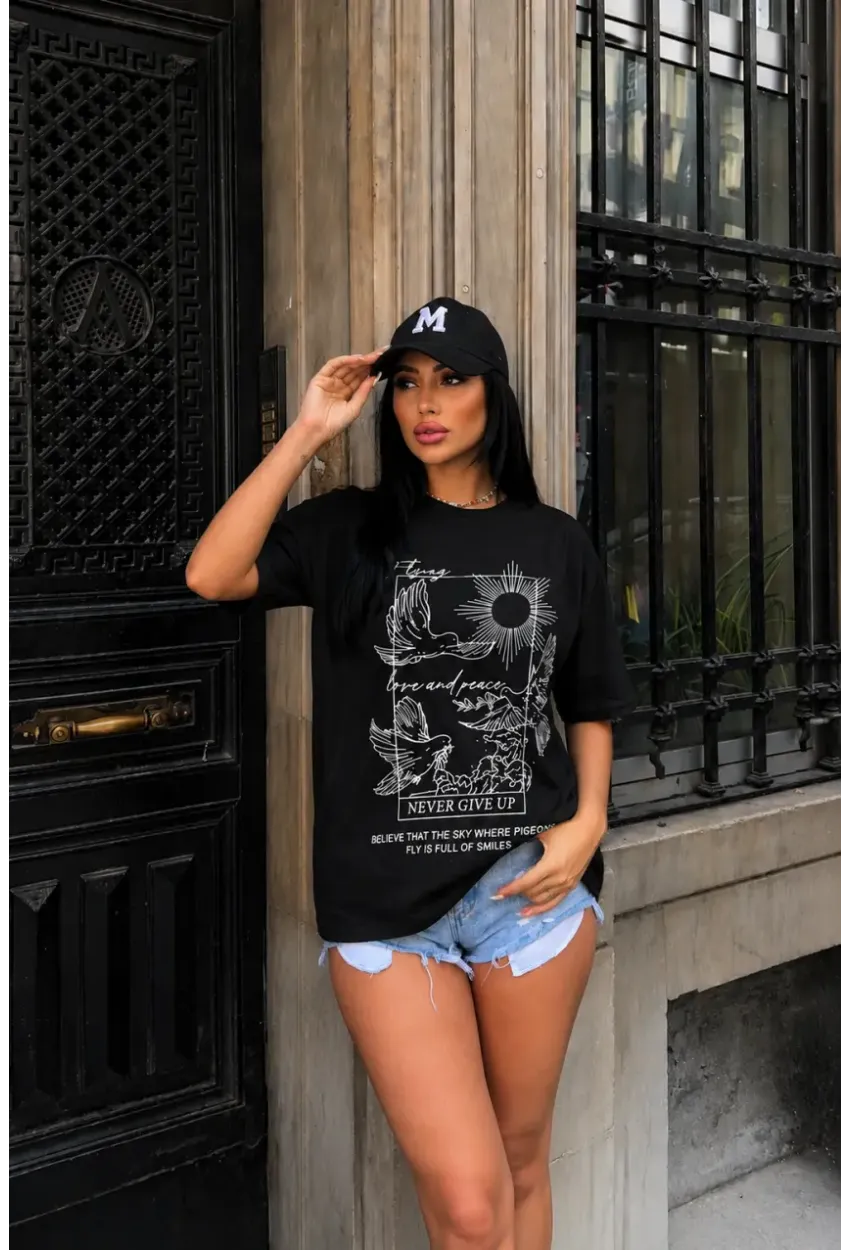 Siyah Güvercin ve Güneş Baskılı Oversize Penye T-Shirt – “Never Give Up” Yazılı Minimal Tasarım