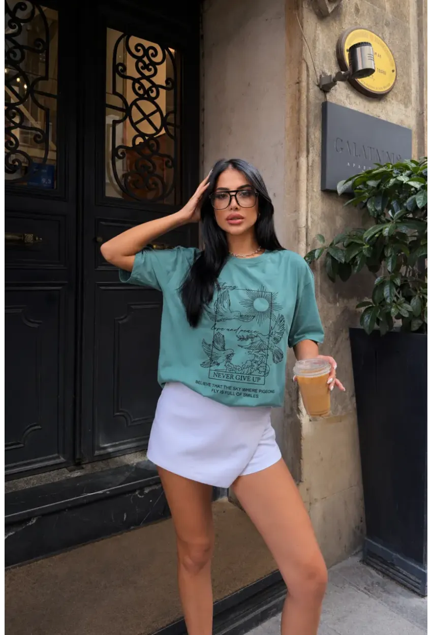 Yeşil Güvercin ve Güneş Baskılı Oversize Penye T-Shirt – “Never Give Up” Yazılı Minimal Tasarım