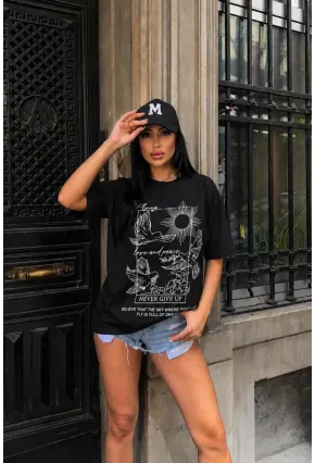 Siyah Güvercin ve Güneş Baskılı Oversize Penye T-Shirt – “Never Give Up” Yazılı Minimal Tasarım